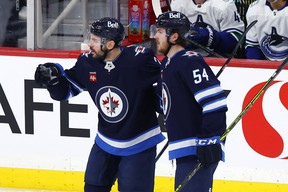 Le secondeur des Jets de Winnipeg Dylan Demelo (L) célèbre son but en infériorité numérique avec son coéquipier Dylan Samberg