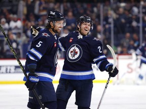 Nikolaj Ehlers (right) celebrates with teammate Brenden Dillon after scoring his first goal of the season in the second period for the Winnipeg JetsSunday
