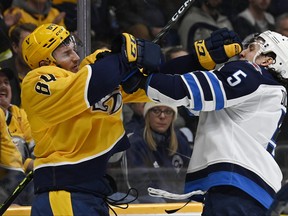Winnipeg Jets defenceman Brenden Dillon (5) scuffles with Nashville Predators left wing Tanner Jeannot (84) during the second period in Nashville on Tuesday night.
