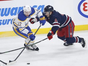 Winnipeg Jets' Neal Pionk defends against Buffalo Sabres' Jack Quinn Thursday night. John Woods/The Canadian Press