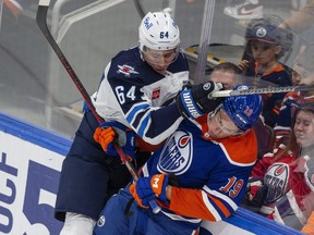 Winnipeg Jets Logan Stanley roughs up Jake Virtanen of the Oilers during a game in Edmonton earlier this season.