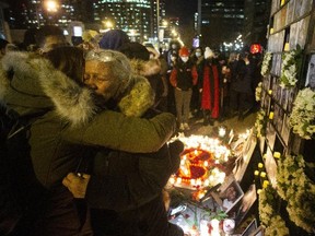 Akram Shojae (second right) is comforted at a vigil in Toronto on Jan. 8, 2022, as she mourns her son, Amir Hossein Ovaysi, daughter-in-law Sara Hamzeei and grandchild Asal Ovaysi. They were among the 176 victims of Ukraine International Airlines Flight PS752 that was shot down by Iran's military on Jan. 8, 2020.