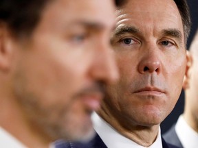 Then-Finance Minister Bill Morneau looks at Prime Minister Justin Trudeau during a press conference in Ottawa, March 11, 2020.