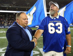 L'ancien Blue Bomber de Winnipeg Chris Walby (à droite), serre la main du bombardier en chef Wade Miller pendant la mi-temps du match de l'équipe contre les Alouettes de Montréal après que Walby a été nommé sur le ring d'honneur au Investors Group Field Winnipeg le vendredi 24 juin 2016. Kevin King /Soleil de Winnipeg