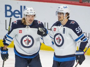 Winnipeg Jets left wing Axel Jonsson-Fjallby (71) celebrates a goal scored by center Mark Scheifele (55) in the third period against the Ottawa Senators at the Canadian Tire Centre in Ottawa on Saturday, Jan. 21, 2023.