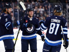 Winnipeg Jets left wing Nikolaj Ehlers (27) celebrates his second period goal with Winnipeg Jets defenseman Brenden Dillon (5) and Winnipeg Jets left wing Kyle Connor (81) against the Vancouver Canucks at Canada Life Centre in Winnipeg on Sunday, Jan. 8, 2023.