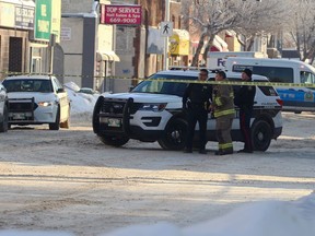 Police and fire officials talk near an apartment block on Sargent Avenue in Winnipeg which was the scene of a fire on Tues., Jan. 3, 2023. One person was taken to hospital in critical condition. KEVIN KING/Winnipeg Sun