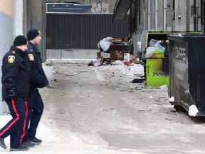 Police officers walk by a garbage-strewn lane in downtown Winnipeg on Wed., Jan. 18, 2023. KEVIN KING/Winnipeg Sun