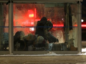 A person stands in a bus shack, surrounded by blankets, in Winnipeg on Tuesday January 24, 2023. Chris Procaylo/Winnipeg Sun