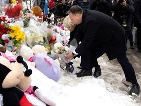 Quebec Premier François Legault and wife Isabelle Brais leave flowers and a teddy bear as they visit the site of the fatal bus crash in Laval on Thursday, February 9, 2023.