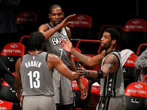 James Harden #13, Kevin Durant #7, and Kyrie Irving #11 of the Brooklyn Nets high-five after coming off the court during the second half against the Miami Heat at Barclays Center on Jan. 25, 2021 in Brooklyn.