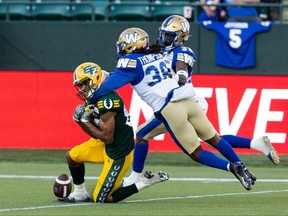 Edmonton Elks’ Kenny Lawler (89) drops a pass while being tackled Winnipeg Blue Bombers’ Malcolm Thompson (36) during first half CFL football action at Commonwealth Stadium in Edmonton, on Friday, July 22, 2022. Ian Kucerak/Postmedia