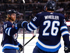 L'ailier gauche des Jets de Winnipeg Kyle Connor (81) célèbre la deuxième période avec un but en avantage numérique de l'ailier droit Blake Wheeler des Jets de Winnipeg (26) contre les Blackhawks de Chicago au Canada Life Centre de Winnipeg le samedi 11 février 2023.