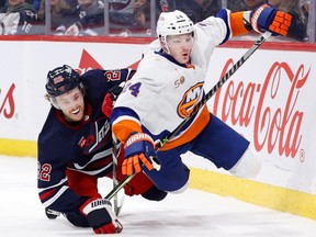 Winnipeg Jets center Mason Appleton (22) and New York Islanders defenceman Scott Mayfield (24) collide in the second period at Canada Life Centre in Winnipeg on Sunday, Feb. 26, 2023.