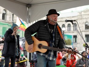Rock legend Neil Young performs during a rally against the destruction of old growth forests on the front lawn of the legislature in Victoria, B.C., on Saturday, February 25, 2023.