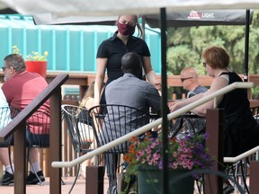 A waitress attends to a table on a patio at The Forks in Winnipeg on Sun., June 27, 2021.