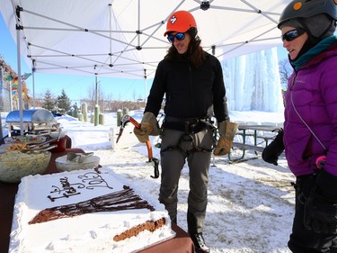 Charles Roy (left), vice-president Club d'escalade de Saint-Boniface, cuts a ceremonial cake with an ice tool during its annual ice climbing festival Festiglace in Winnipeg on Sunday, Feb. 5, 2023.