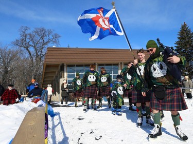 A piper from the Queen's Own Cameron Highlanders of Canada leads members of the Camerons onto the ice for the Great Canadian Kilt Skate on the duck pond at Assiniboine Park in Winnipeg on Sunday, Feb. 26, 2023.