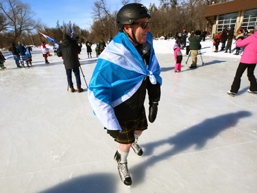 A man wrapped in a Scottish flag during the Great Canadian Kilt Skate on the duck pond at Assiniboine Park in Winnipeg on Sunday, Feb. 26, 2023.