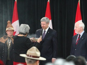 AFN National Chief Shawn A-in-chut Atleo with Prime Minister Stephen Harper and Governor General David Johnston take part in the smudge ceremony during the 2012 Crown-First Nations meeting in Ottawa.