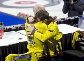 Matt Dunston du Manitoba partage une étreinte émotionnelle avec l'entraîneur Adam Kingsbury après avoir arraché une victoire de 7-5 sur Brendan Butcher en demi-finale du Brier Tim Hortons dimanche.