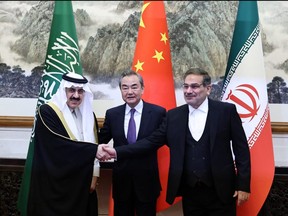 Wang Yi, a member of the Political Bureau of the Communist Party of China (CPC) Central Committee and director of the Office of the Central Foreign Affairs Commission, Ali Shamkhani, the secretary of Iran’s Supreme National Security Council, and Minister of State and national security adviser of Saudi Arabia Musaad bin Mohammed Al Aiban pose for pictures during a meeting in Beijing, China March 10, 2023. China Daily via REUTERS