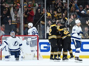 Boston Bruins right wing Garnet Hathaway (21) is congratulated by centre Jakub Lauko (94) and left wing Tomas Nosek (92) after scoring a goal during the second period against the Tampa Bay Lightning at TD Garden in Boston on March 25, 2023.