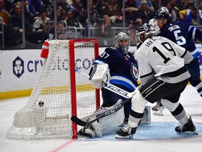 Alex Iafallo of the Kings scores what turned out to be the winning goal on Jets goalie Connor Hellebuyck Saturday in Los Angeles.
