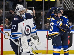 Winnipeg Jets goalie Connor Hellebuyck reacts as the St. Louis Blues celebrate their second goal during Sunday's win by the Blues at Enterprise Center.