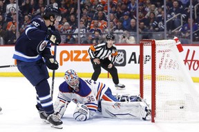 L'ailier des Jets Morgan Barron marque lors d'une échappée contre le garde des Oilers Jack Campbell.