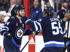 Josh Morrissey (left) celebrates his game-winning goal with centre Mark Scheifele during the Jets 7-5 win over the Edmonton Oilers Saturday night.