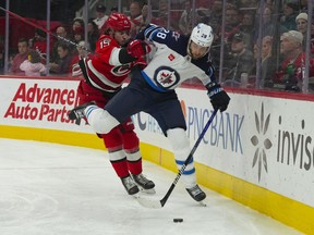 Winnipeg Jets centre Kevin Stenlund (right) is checked by Carolina Hurricanes defenceman Dylan Coghlan during the second period 
at PNC Arena on Tuesday night.