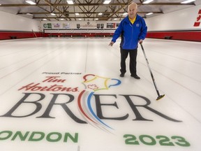 Peter Inch who will be running the Brier poses with a logo on an associated rink at the St. Thomas Curling Club. Photograph taken on Monday February 20, 2023. (Mike Hensen/The London Free Press)