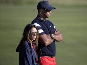 Tiger Woods, top, assistant U.S. team captain, and his girlfriend Erica Herman, watch play on the 17th hole during the final round of the Presidents Cup at Liberty National Golf Club in Jersey City, N.J., Oct. 1, 2017.