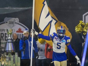 Winnipeg Blue Bombers defensive lineman Willie Jefferson (5) carries a flag onto the field for the 109th Grey Cup at Mosaic Stadium on Sunday, Nov. 20, 2022 in Regina.