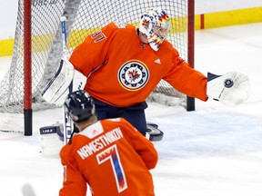 Le gardien de but des Jets de Winnipeg Connor Hellebock (37) attrape un tir de Vladislav Namestnikov (7) avant un match contre les Oilers d'Edmonton au Canada Live Centre à Winnipeg le samedi 4 mars 2023.