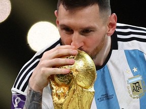 Soccer Football - FIFA World Cup Qatar 2022 - Final - Argentina v France - Lusail Stadium, Lusail, Qatar - December 18, 2022. Argentina's Lionel Messi kisses the trophy as he celebrates winning the World Cup.