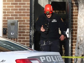 A fire investigator exits an apartment block on Sargent Avenue in Winnipeg which was the scene of a fire on Tuesday, Jan. 3, 2023. One person was taken to hospital in critical condition where she later died.