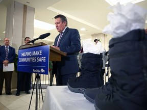 Two pairs of new winter boots for members of the Downtown Community Safety Partnership team to pass on to people in downtown Winnipeg without proper footwear sit on a table as Finance Minister Cliff Cullen speaks during a press conference at Cityplace in Winnipeg on Monday March 6, 2023. Tradition has the finance minister buying a new pair of shoes before presenting a new budget, as Manitoba will Tuesday.