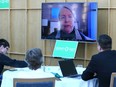 Janine Gibson addresses party members via video screen after being named the new provincial leader of the Green Party of Manitoba at the Assiniboine Park Pavilion in Winnipeg on Sunday, March 26, 2023.