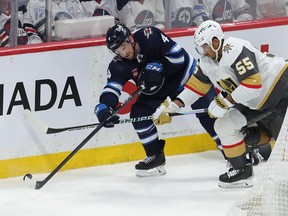 Neal Pionk of the Jets battles with Keegan Kolesar of the Golden Knights during Game 3 Saturday at Canada Life Centre.