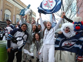 Fans dressed in white celebrate outside Canada Life Centre on Monday during Game 4 of a playoff series against the Vegas Golden Knights.