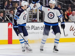 Jets forwards Adam Lowry and Blake Wheeler celebrate an empty-net goal as the Jets beat the Golden Knights 5-1 in Vegas on Tuesday.