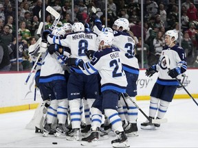 Winnipeg Jets players celebrate after the 3-1 win against the Minnesota Wild of an NHL hockey game, Tuesday, April 11, 2023, in St. Paul, Minn. (AP Photo/Abbie Parr)
