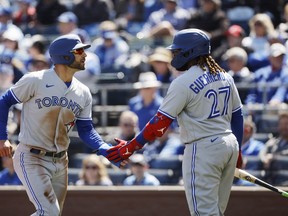 Blue Jays' Kevin Kiermaier (left) is congratulated by Vladimir Guerrero Jr. at home plate after scoring off a Bo Bichette single during the second inning against the Kansas City Royals in Kansas City, Mo., Thursday, April 6, 2023.