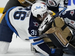 Winnipeg Jets center Morgan Barron (36) gets his face cut on the skate of Vegas Golden Knights goaltender Laurent Brossoit (39) during the first period of Game 1 in Las Vegas last night.