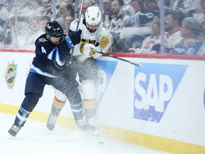 Apr 24, 2023; Winnipeg, Manitoba, CAN; Winnipeg Jets defenseman Neal Pionk (4) checks Vegas Golden Knights forward Chandler Stephenson (20) during the first period in game four of the first round of the 2023 Stanley Cup Playoffs at Canada Life Centre. Mandatory Credit: Terrence Lee-USA TODAY Sports