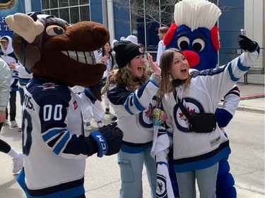 A couple of Jets fans pose for a selfie with mascots Benny and Mick E. Moose during the Winnipeg Whiteout Street Party on Saturday, April 22, 2023, outside Canada Life Centre in Winnipeg prior to the start of Game 3 of the Jets-Vegas Golden Knights NHL playoff series.