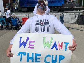 A Jets fan poses in front of the stage during the Winnipeg Whiteout Street Party on Saturday, April 22, 2023, in Winnipeg prior to the start of Game 3 of the Jets-Vegas Golden Knights NHL playoff series.