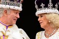 Britain's King Charles III (L) looks at Queen Camilla as they stand on the Buckingham Palace balcony, in London, following their coronations, on May 6, 2023.